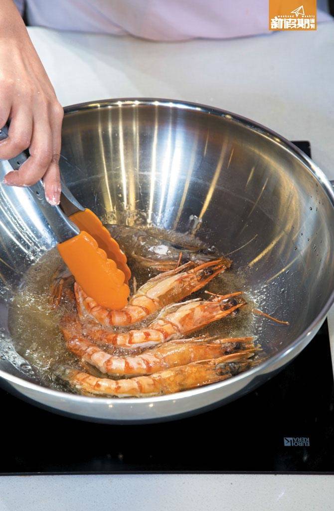 團年飯菜單食譜 2. 大蝦沾上麵粉，放入滾油中半煎炸成熟，盛起瀝乾油份。