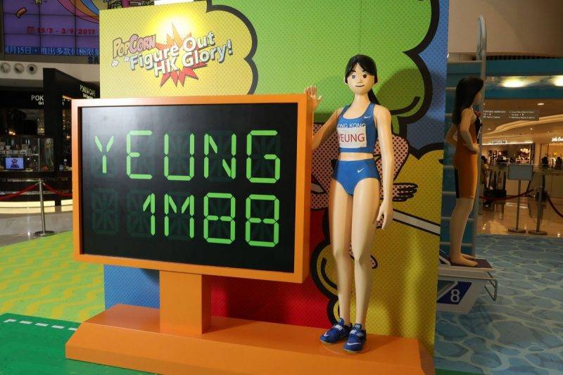 運動 「跳高女神」楊文蔚企喺1.88米嘅計分牌旁邊，重現當時打破香港紀錄嘅一刻。
