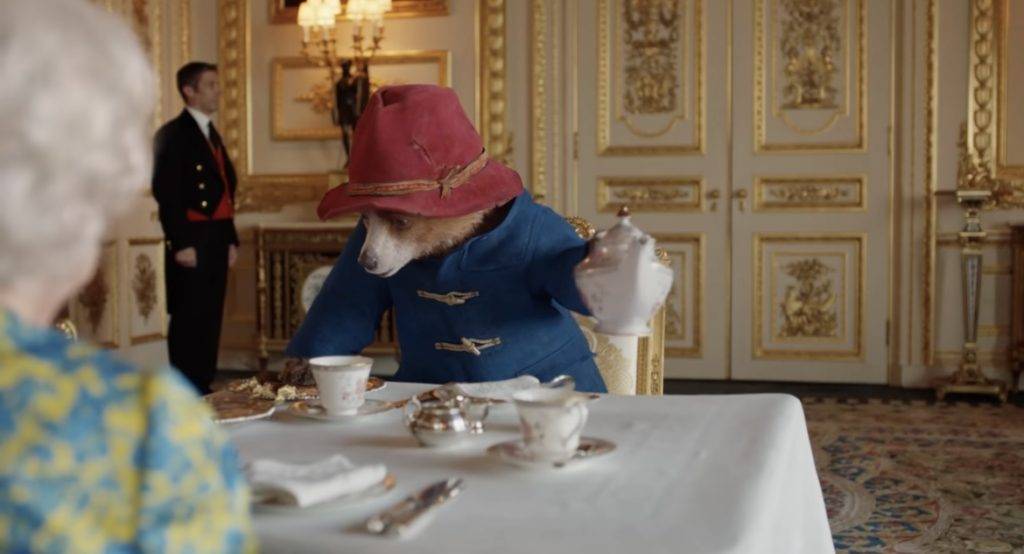 英女王 英女皇 柏靈頓熊經常身穿藍色雨褸，頭戴紅色禮帽，手持一個旅行箱，猶如典型的英國紳士