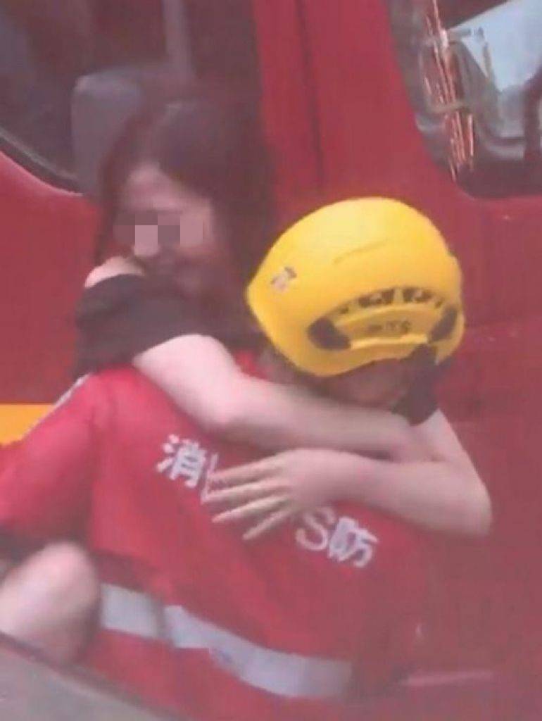 黑雨 女乘客 該名被困女乘客獲消防員勇救，緊緊被消防員抱在懷內