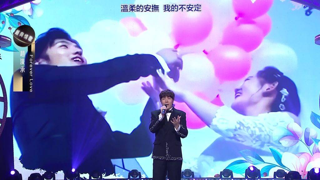 中年好聲音3 趙浚承 趙浚承演唱時身後嘅大屏幕更播出唔少佢與老婆嘅甜蜜合照。(圖片來源:TVB)