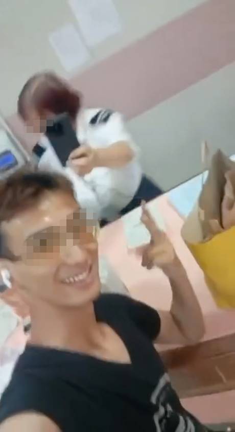 瘋狂外賣員 女保安就邊舉機拍攝邊登記,期間聽到外賣員挑釁:「你真係唔好彩啊!遇著我瘋狂外賣員!」、「一齊入鏡先」,隨即他舉V字手勢與女保安自拍並大聲叫囂:「瘋狂外賣員!」。(圖片來源:FB@ 香港外賣及速遞平台綜合交流群)