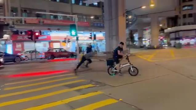 的士 期間的士司機向前撲,試圖捉住單車車尾,惟失手落空在地上翻滾。(圖片來源:FB@車cam L(香港群組) )