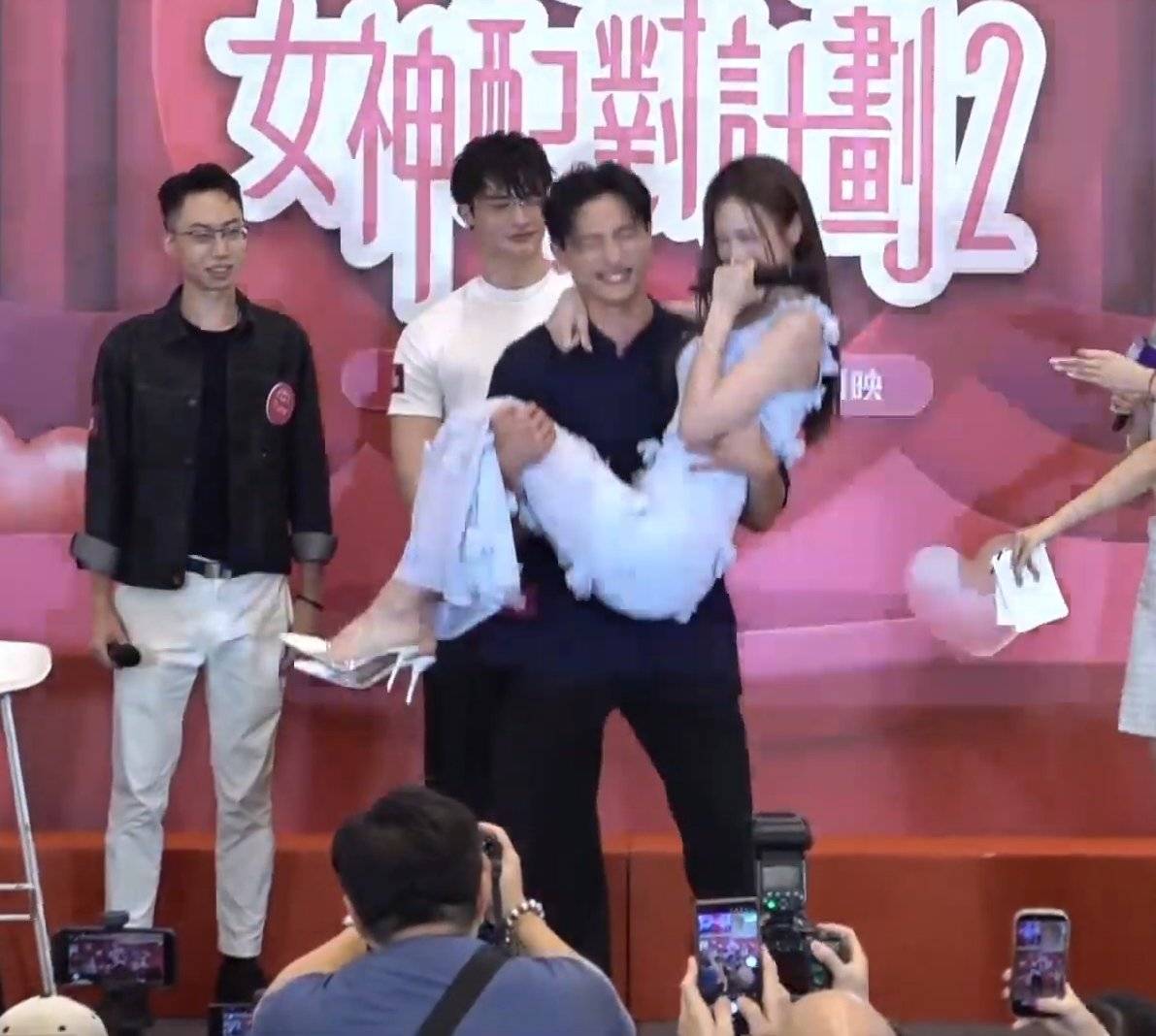 女神配對計劃2 mark 在商場活動中Mark Ng吳俊峰抱起何沛珈做深蹲,面容扭曲。(圖片來源:TVB)