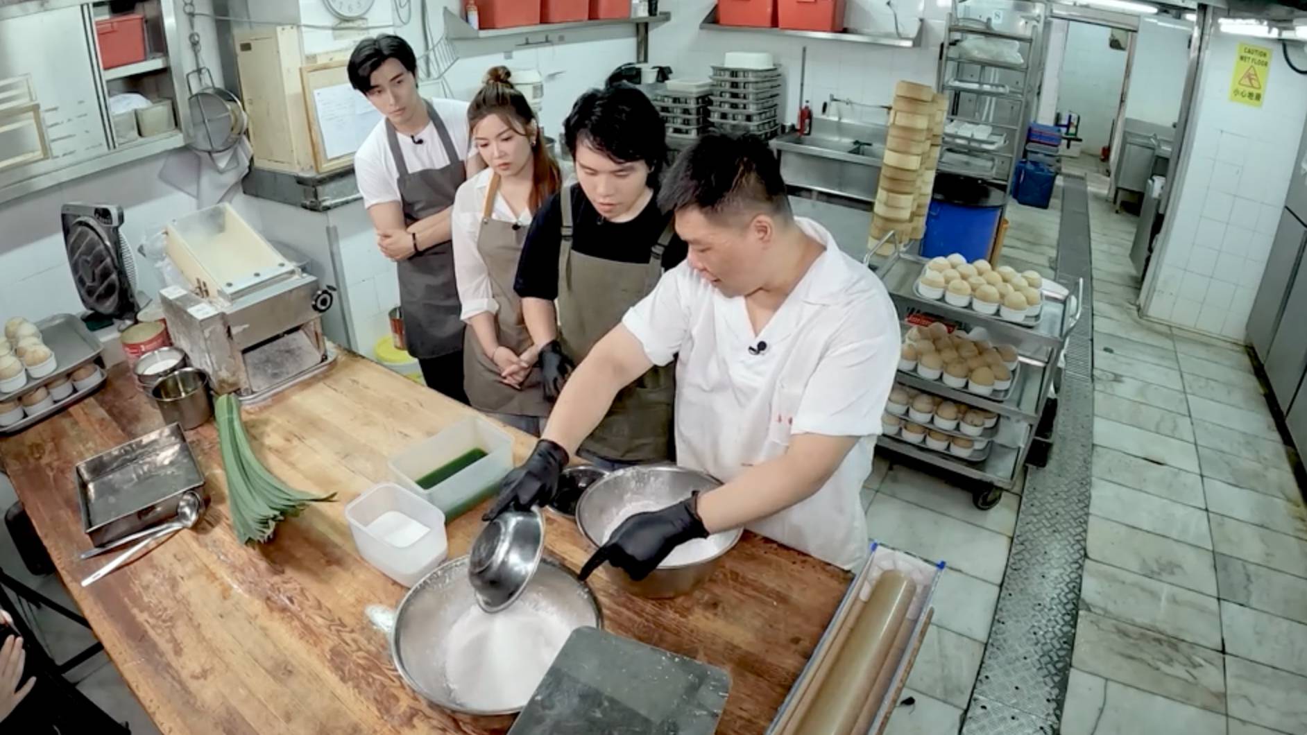 viutv 沿路幫緊你 Theo 專心向輝哥請教泰式千層糕的製作技巧,希望能還原爸爸當年做給媽媽的味道。(圖片來源:ViuTV)