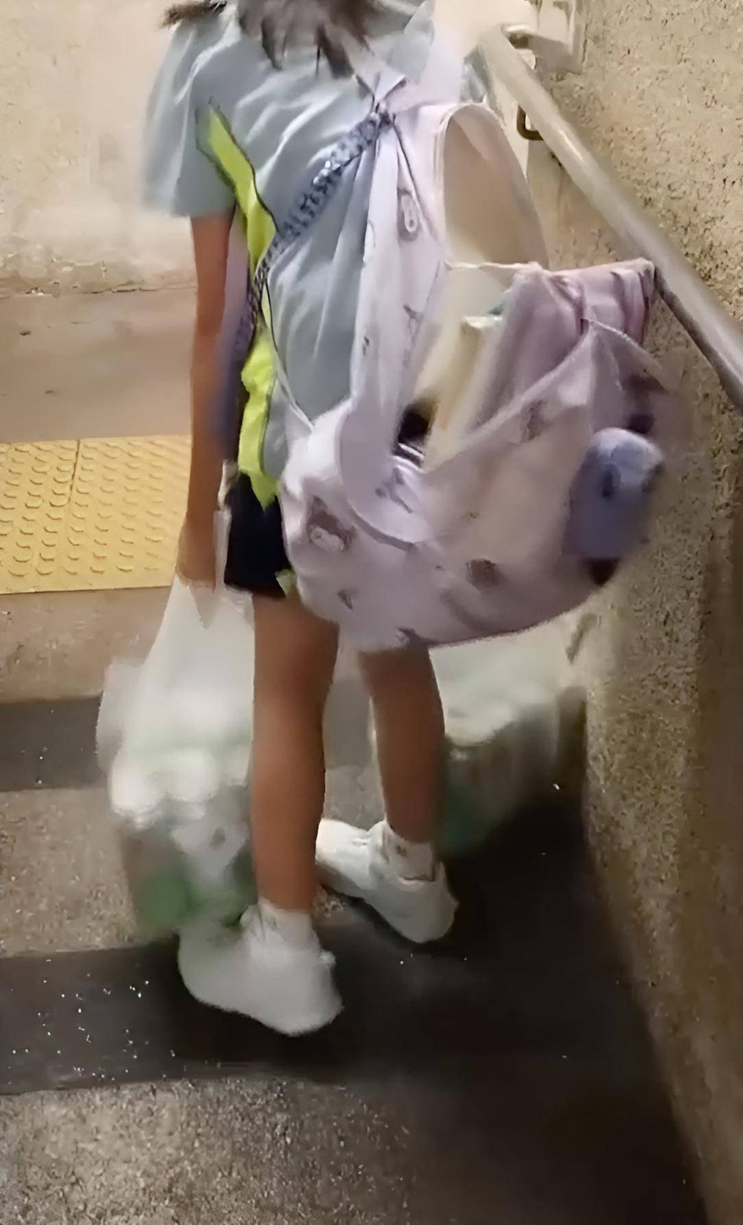 綜援戶 虐兒 11歲女童背着破爛背囊,手提兩大袋啤酒吃力行走,畫面令不少網民關注其日常照顧情況。(圖片來源:影片截圖@Facebook群組「富泰邨 Fu Tai Estate」)